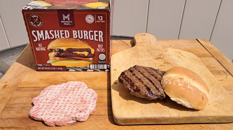 Box of Member's Mark smashed burgers with frozen patty and cooked burger