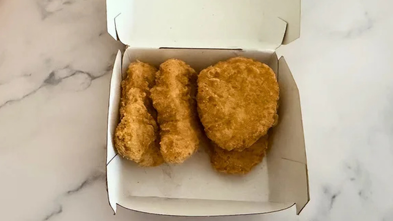 Chicken McNuggets in a container on marble background