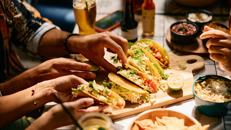 hands reaching for tacos in restaurant