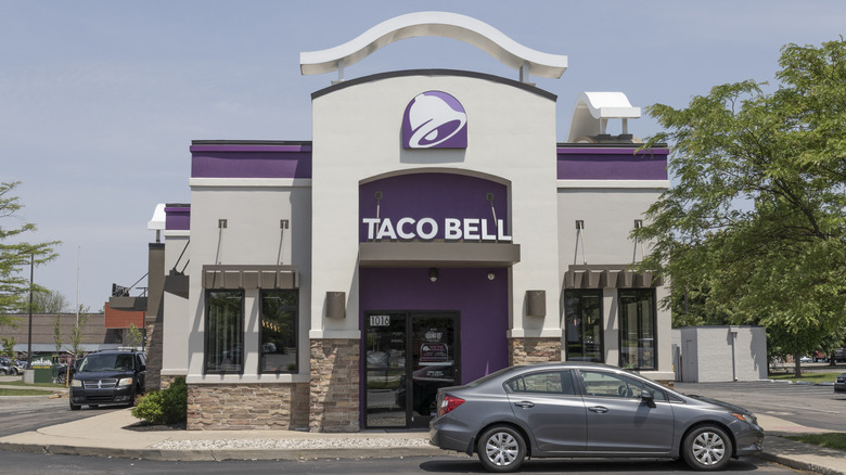 Taco Bell restaurant sign with a car