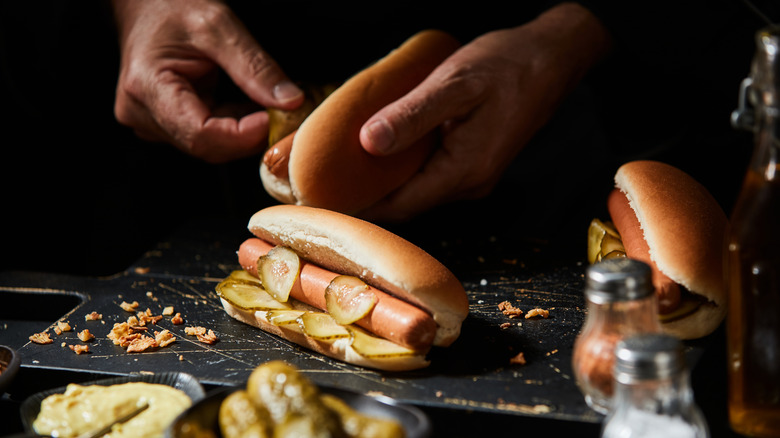 someone preparing hot dogs on board