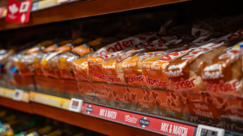 various packages of wheat bread loaves on shelves