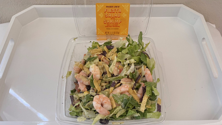 An open box of Fiesta Salad with Shrimp from Trader Joe's sitting on a white tray