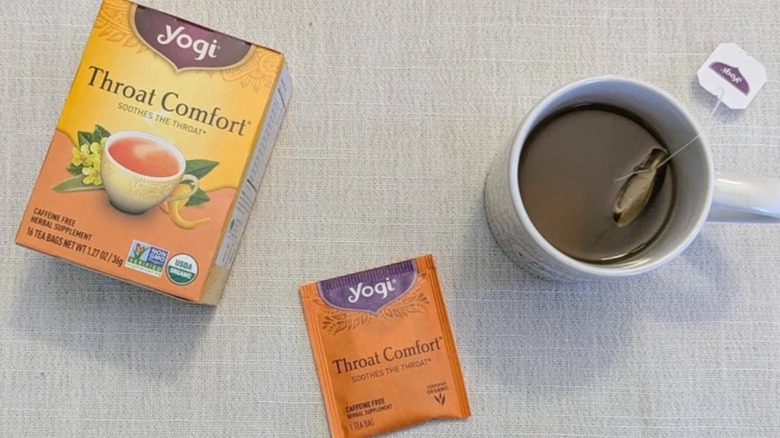 Box of Yogi Throat Comfort tea beside a mug of brewed tea