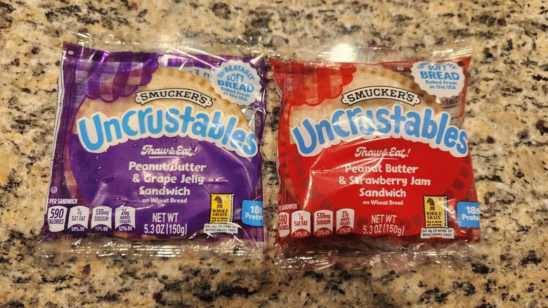 Grape and strawberry Uncrustables side by side on a countertop