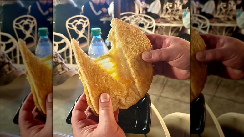 Hands holding a toasted cheese from Jolly Holiday