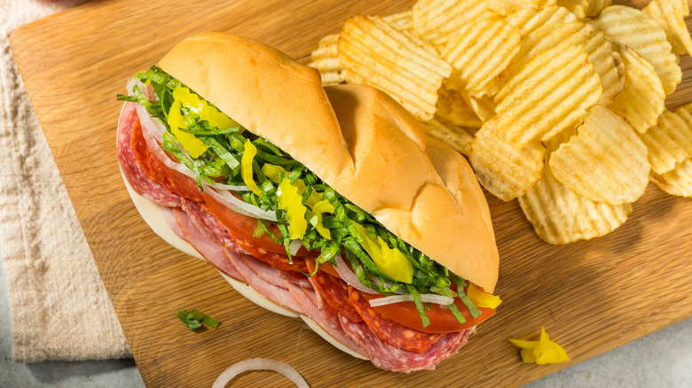 Italian sub and chips on a wooden board
