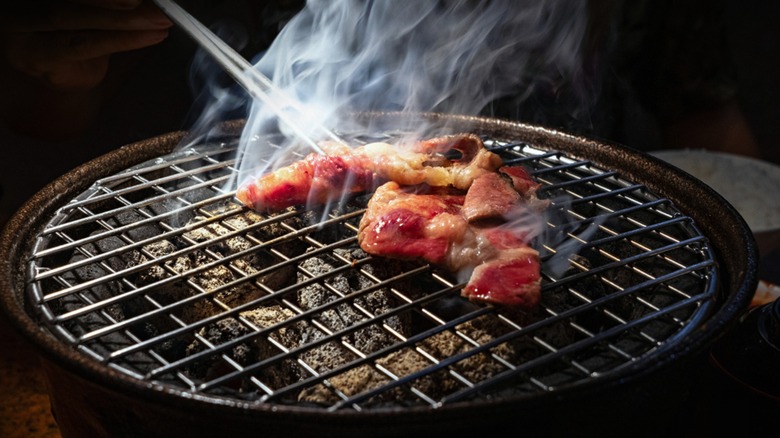 Slices of meat being cooked on a tabletop grill
