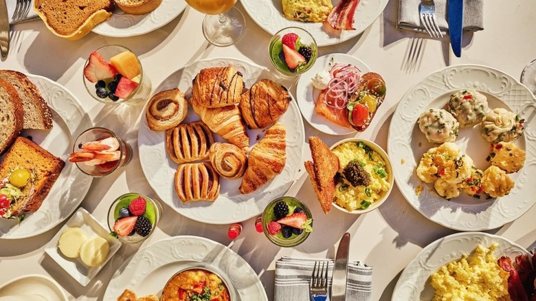 Assortment of brunch dishes including croissants, fruit, and eggs