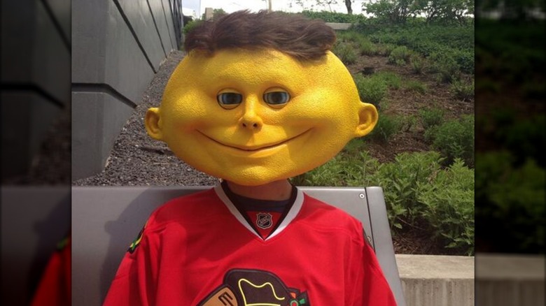 Lemonhead's mascot wearing a jersey sitting outside