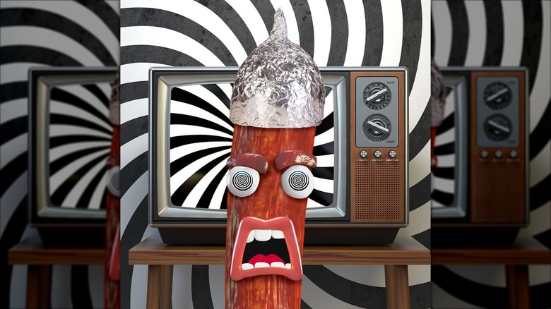 Peperami mascto wearing a tin foil hat by a TV