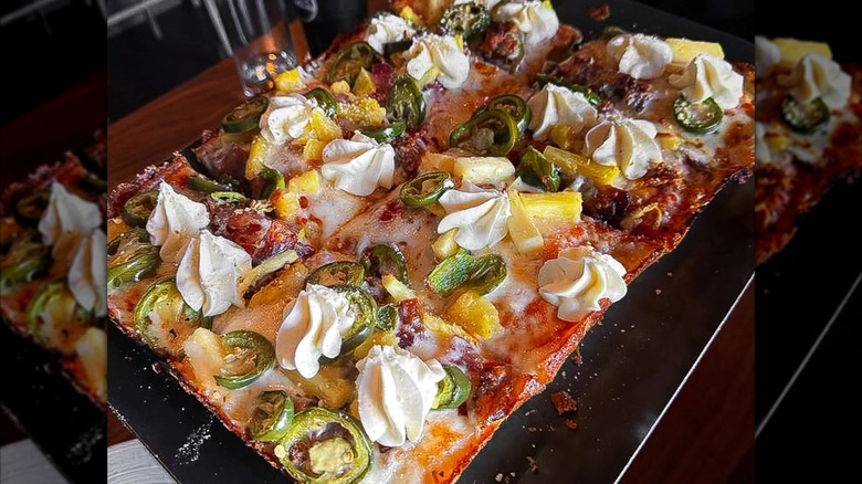 Detroit-style pizza with cheese and jalapeños on a metal tray