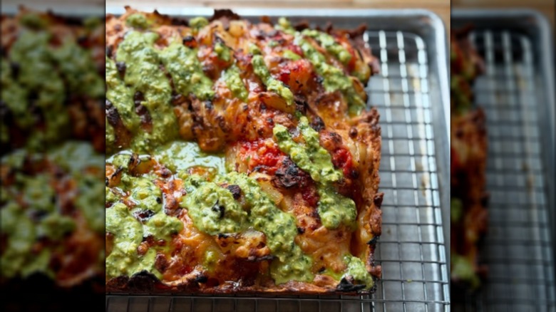 Half of a Detroit-style pizza on a wire rack