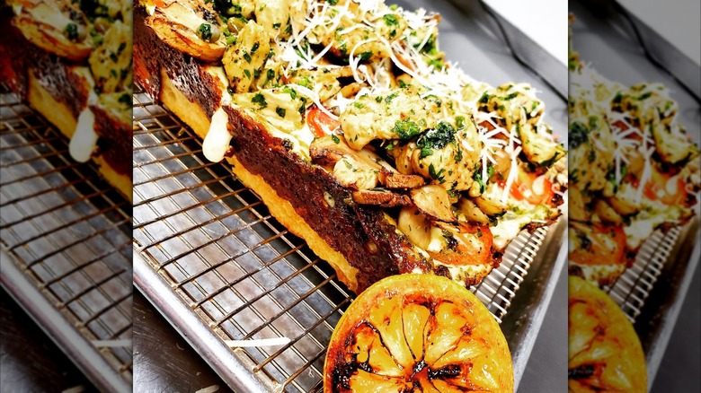 Detroit-style pizza on a metal baking rack with a browned crust