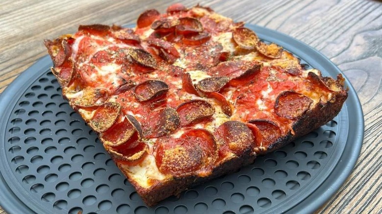 Detroit-style pizza with pepperoni on a round baking tray