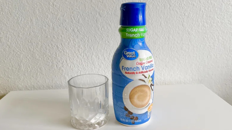 A bottle of Walmart Great Value Sugar-Free French Vanilla Creamer next to a glass