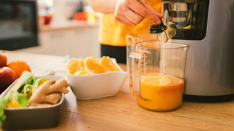 making orange juice in juicer