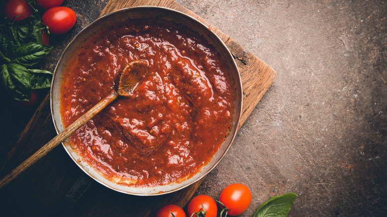 tomato sauce in pot with wooden spoon