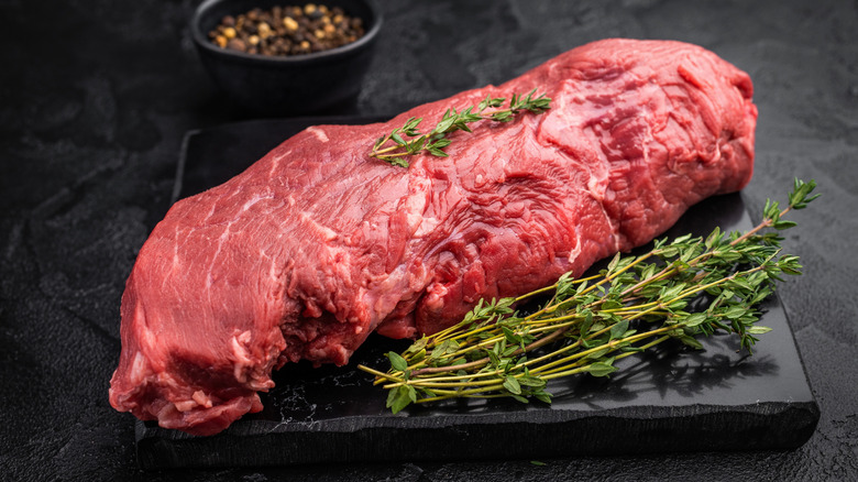 whole beef tenderloin with narrow end included on board with thyme