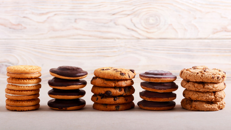 Several Girl Scout Cookies stacked beside each other in front of wooden background