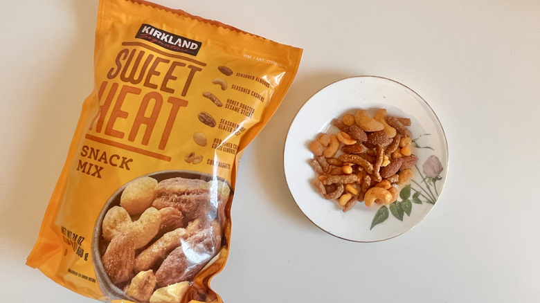 A bag of Costco's Kirkland Signature Sweet Heat snack mix next to a bowl of the mix
