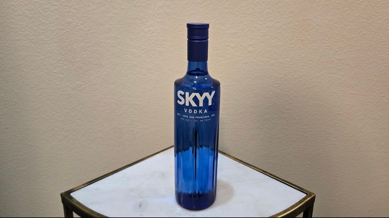 A bottle of Skyy Vodka on a small corner table