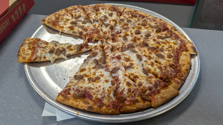 A Chuck E. Cheese pizza on a metal serving tray