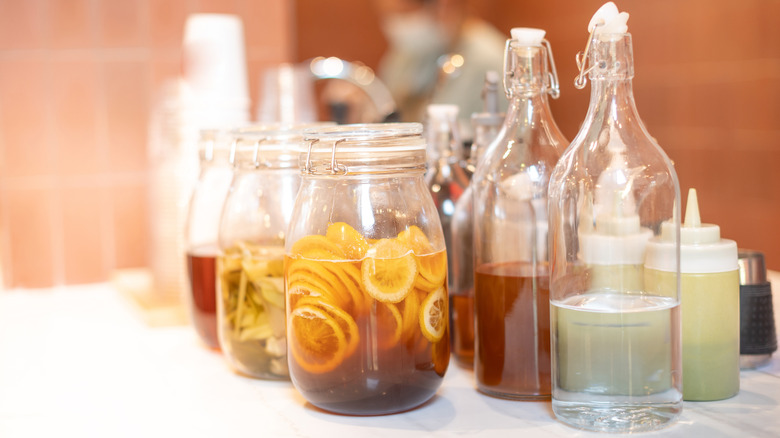 Homemade infusions in several jars with different flavorings.