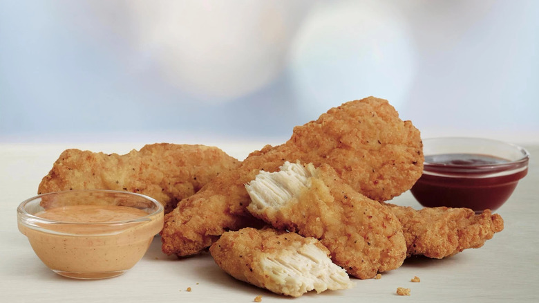 McDonald's Buttermilk Chicken Crispy Tenders on cutting board with two small glass bowls of dipping sauces