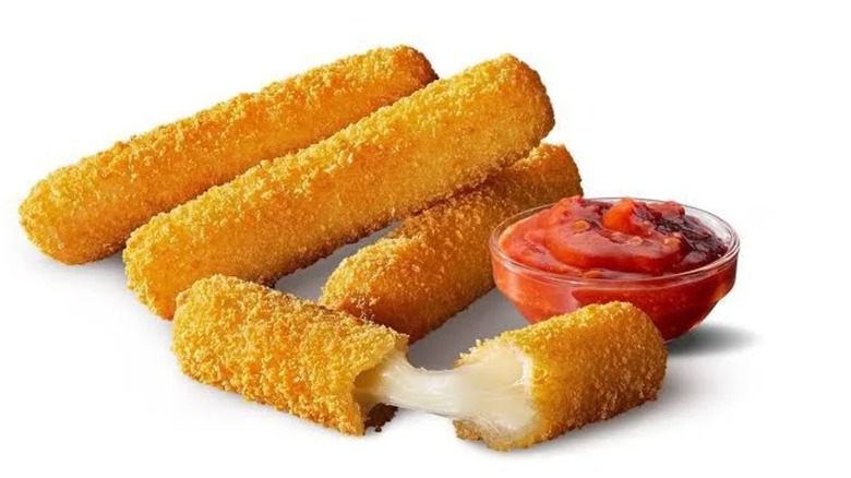 McDonald's mozzarella sticks with marinara sauce on black background