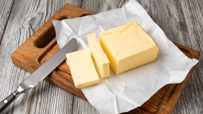 block of butter on a cutting board with a butter knife