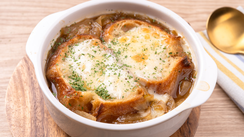 French onion soup with cheesy bread in white bowl