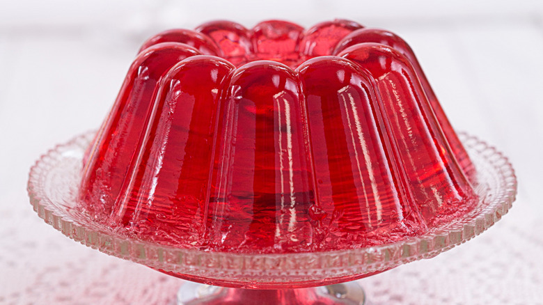 Molded red Jell-O dessert on glass cake stand