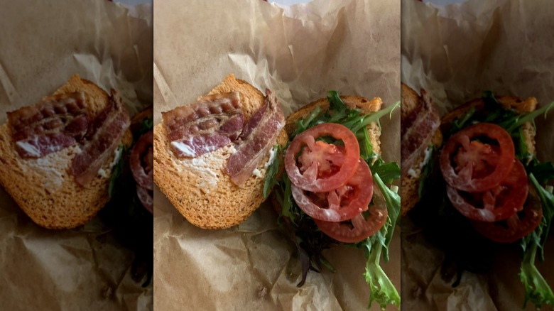 Panera Tomato Basil BLT sandwich opened out on brown parchment paper
