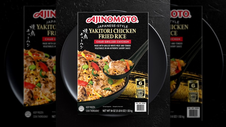 Box of Ajinomoto Yakitori Chicken Fried Rice resting on a black dish before a black background