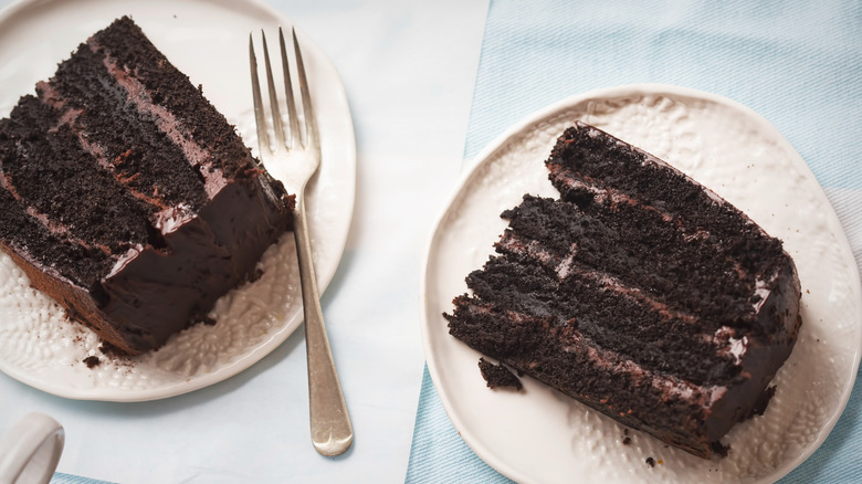 Two slices of Coca-Cola cake on plates with a fork