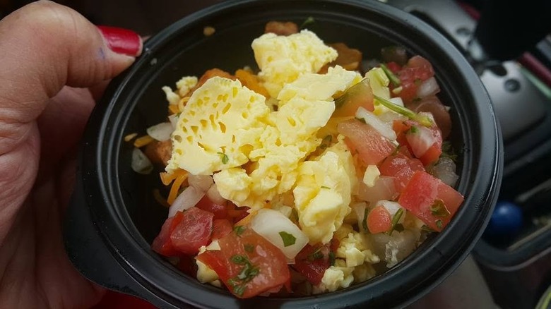 Hand holding Taco Bell Mini Skillet Bowl in car