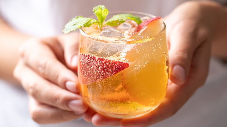 Person holding peach spritz