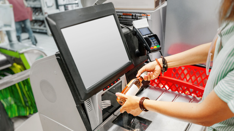 Woman scanning alcohol at self checkout