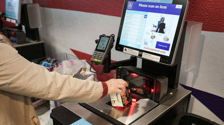 Person scanning at self checkout machine