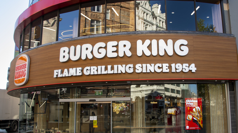The exterior of a Burger King restaurant is pictured with the marketing phrase: "Flame Grilling Since 1954" beneath the store name.