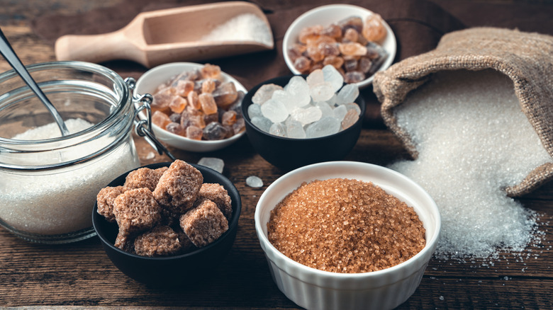 different types of sugar laid out in various containers on a table