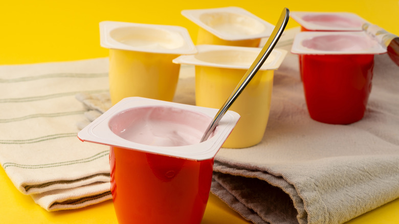 Plastic yogurt containers with a spoon in one