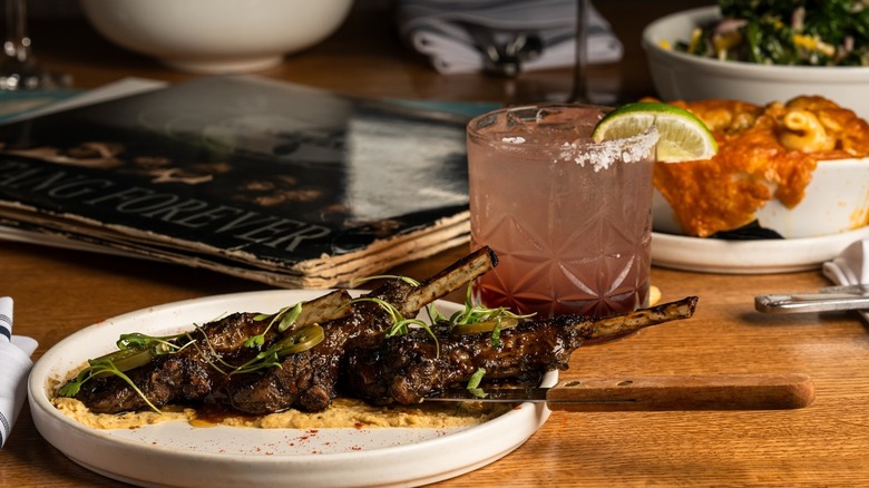 Plate with chops and cocktail on table with vinyl records
