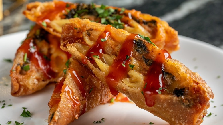 Mac and cheese egg rolls with drizzle of sauce