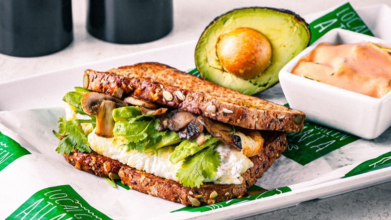 Mushroom and egg sandwich with half an avocado on tray