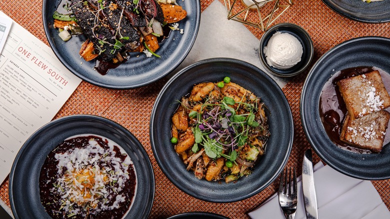 Aerial view of assortment of dishes on black plates on table