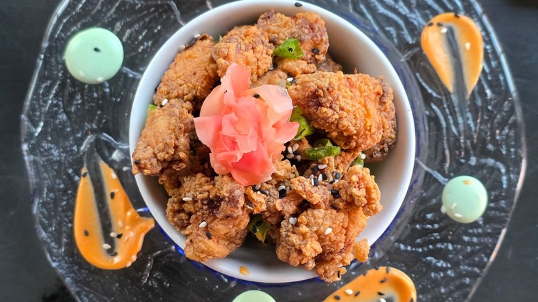 Fried nuggets in bowl with flower on plate with sauces