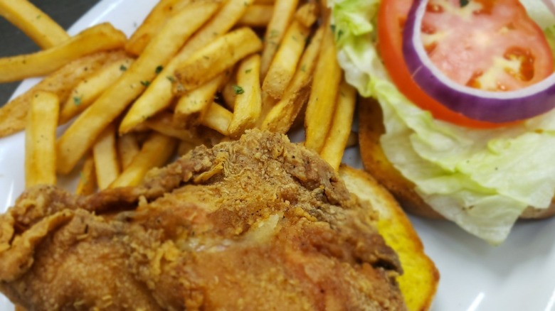 Fried chicken with fries, lettuce, tomato, and onion