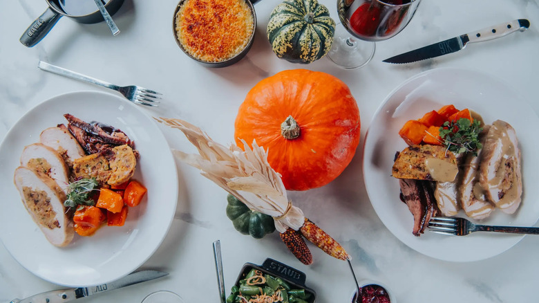 aerial view of dinner table with pumpkin decorations and thanksgiving plates